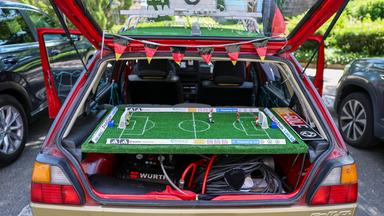 WM, im WM-Golf von zwei deutschen Fans ist die Hutablage durch ein Tipp-Kick-Spielbrett ersetzt worden. Die beiden Fans wollen alle Spiele der Nationalmannschaft mit dem betagten Fahrzeug besuchen. Den Golf mit dem Baujahr 1991 zieren die Autogramme von 37 Welt- und Europameistern aus Deutschland.