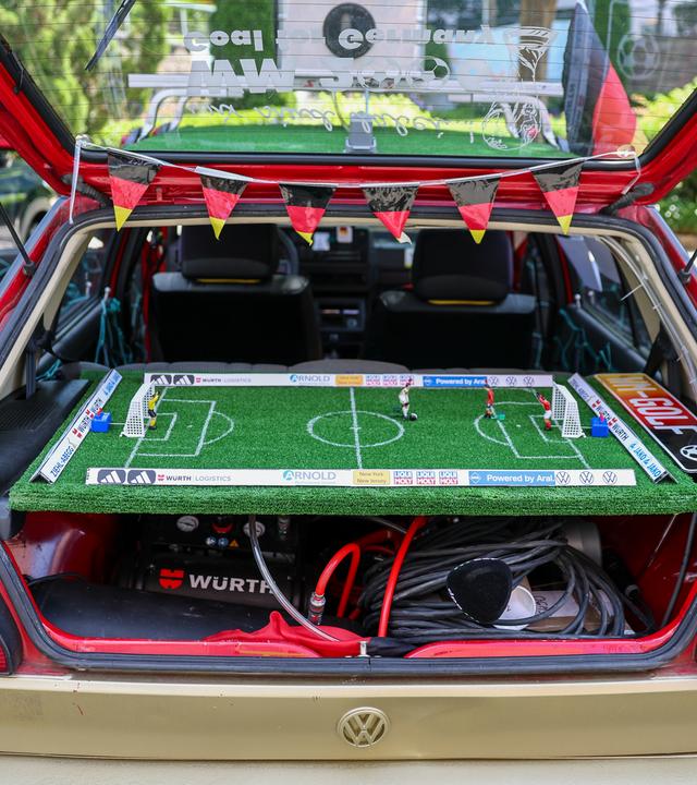 WM, im WM-Golf von zwei deutschen Fans ist die Hutablage durch ein Tipp-Kick-Spielbrett ersetzt worden. Die beiden Fans wollen alle Spiele der Nationalmannschaft mit dem betagten Fahrzeug besuchen. Den Golf mit dem Baujahr 1991 zieren die Autogramme von 37 Welt- und Europameistern aus Deutschland.
