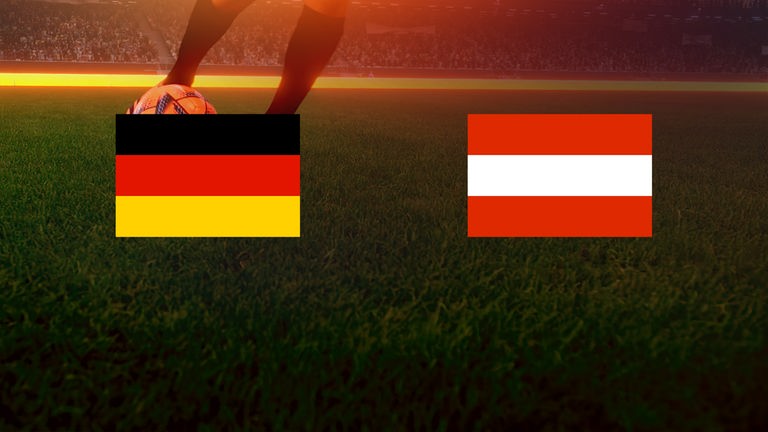 Deutsche und österreichische Flagge vor grünem Rasen.