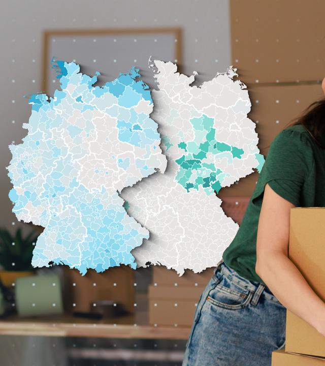 Paar mit Umzugskartons und Deutschland-Karten die zeigen, wo Mieten und wo Kaufen günstiger ist