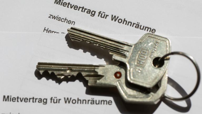 Ein Wohnungsschlüssel liegt auf einem Mietvertrag für eine Wohnung.