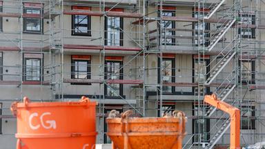 Baugeräte stehen auf einer Baustelle für neue Wohnhäuser.