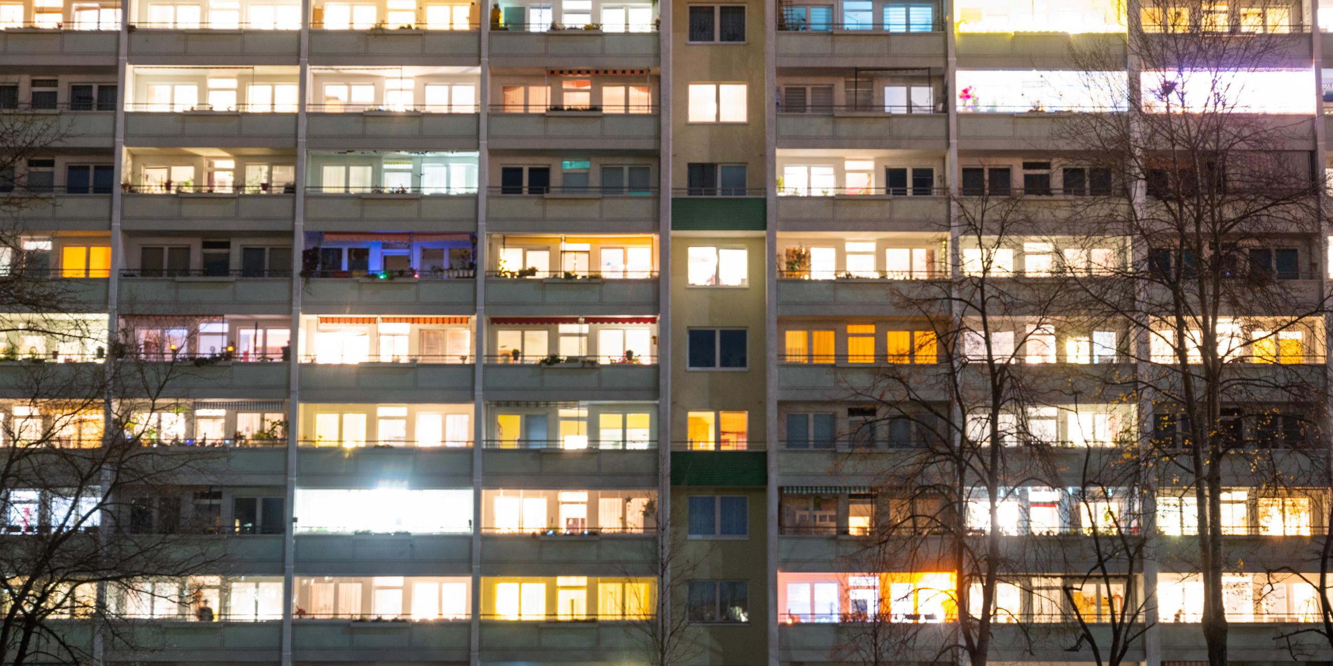 In einem Hochhaus sind einige Fenster beleuchtet. 