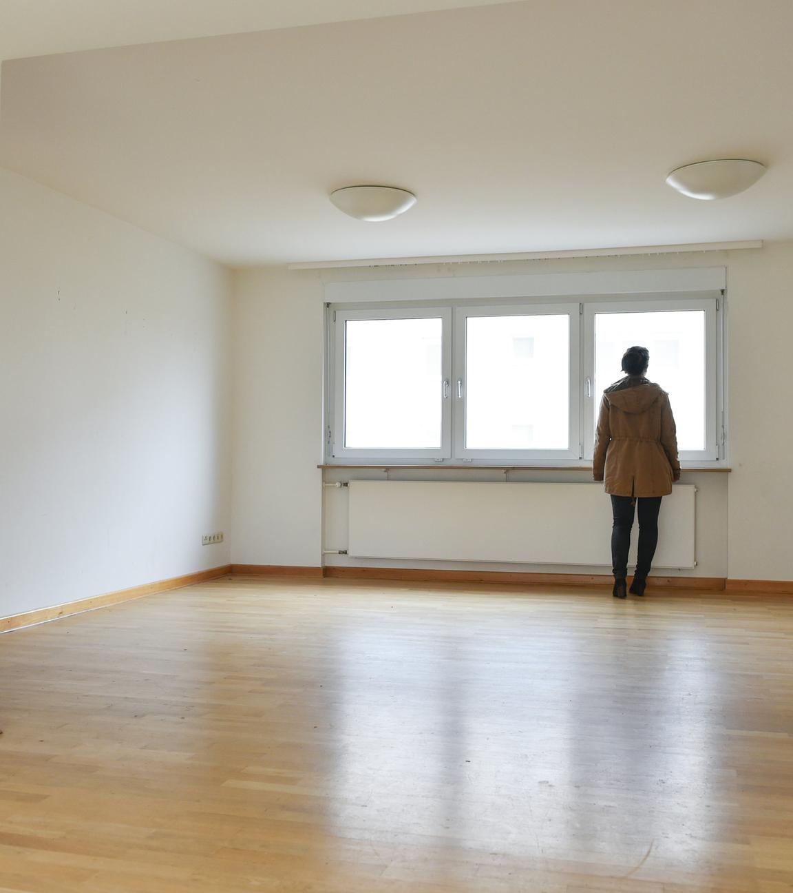 Eine Frau steht in einer leer stehenden Wohnung.
