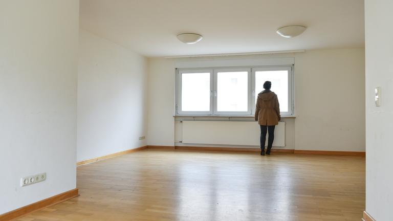 Eine Frau steht in einer leer stehenden Wohnung.