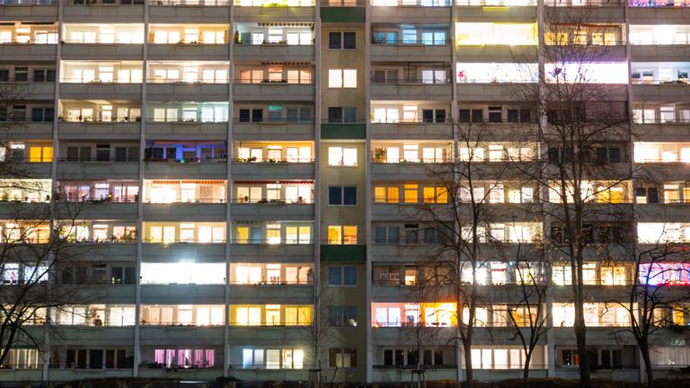 In einem Hochhaus sind einige Fenster beleuchtet. 