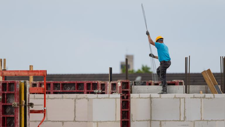 Ein Bauarbeiter arbeitet an einem Rohbau für Eigentumswohnungen im Stadtteil Ehrenfeld.