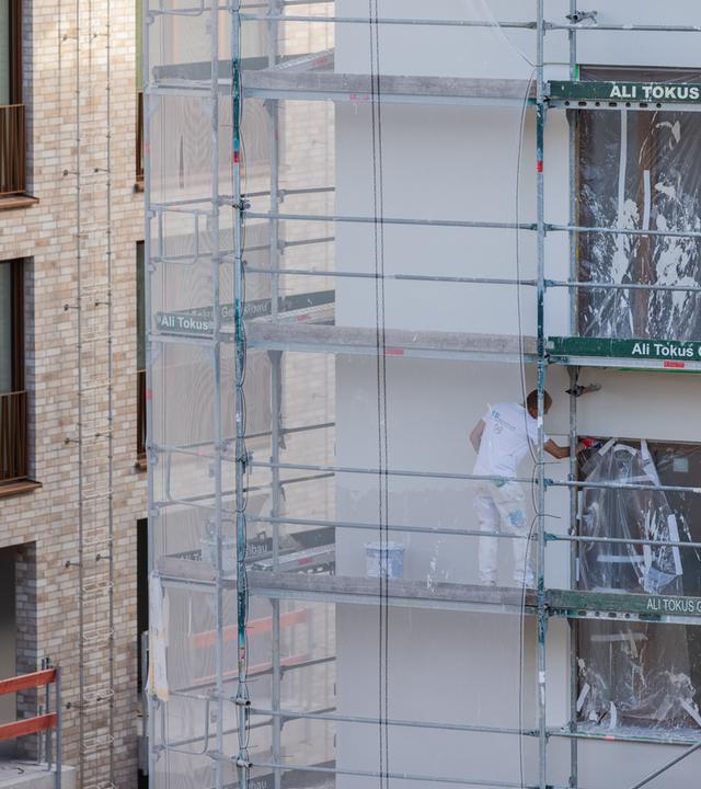 Wohnungsbau in Köln: Arbeiter verputzen ein Haus mit Eigentumswohnungen.