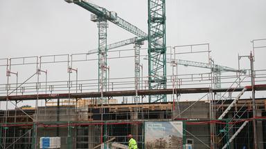 Baustelle eines Hauses mit Gerüst und Kran.