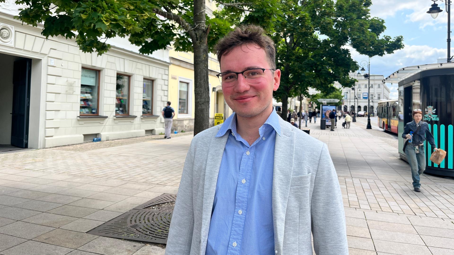 Wojciech steht an einer breiten Straße in Warschau