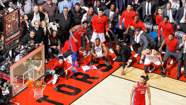 Kanada, Toronto: Kawhi Leonard (in der Hocke, mitte) von den Toronto Raptors sieht zu, wie sein Wurf ins Netz geht.