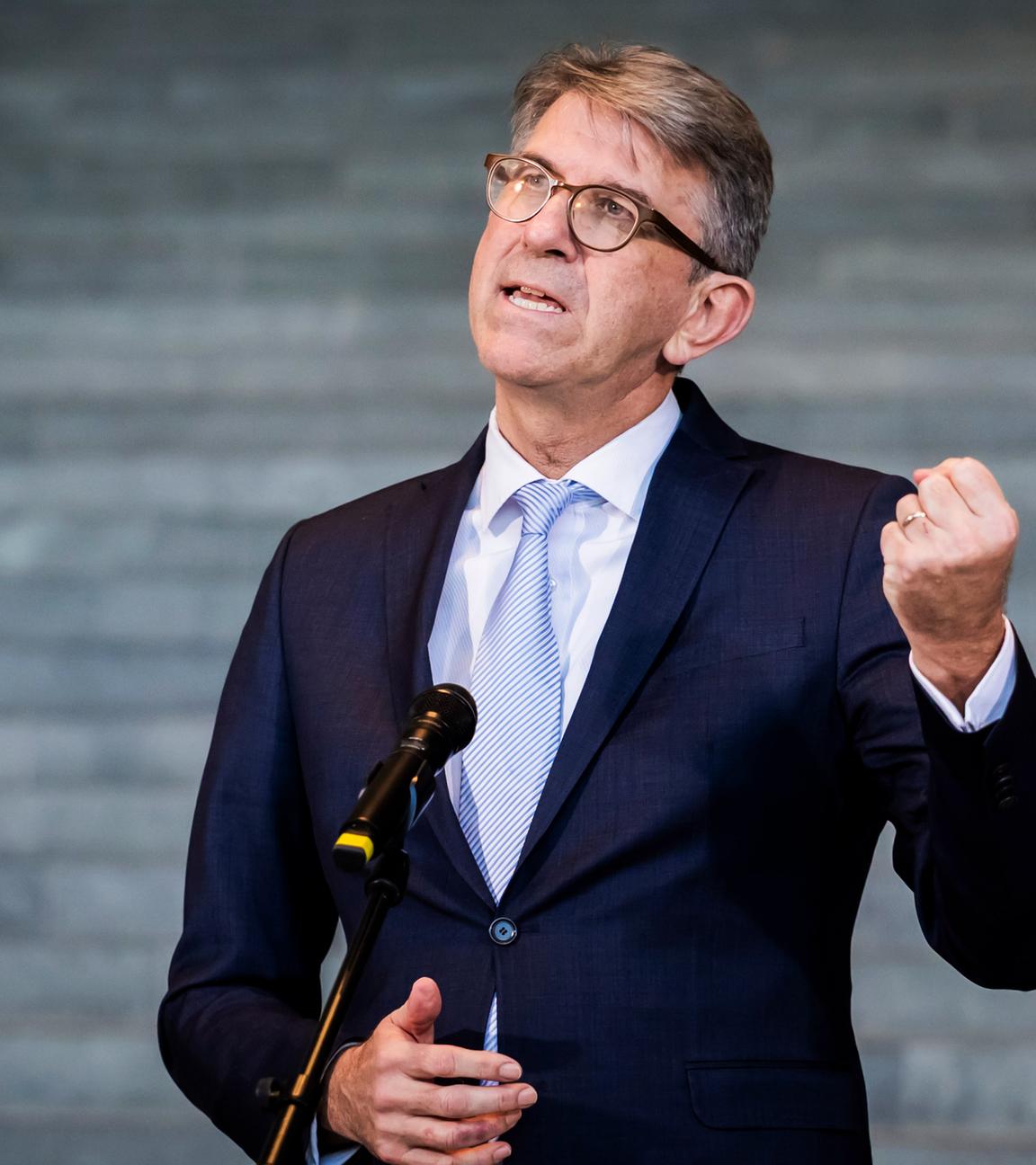 Mann steht am Mikrofon und ballt die Faust