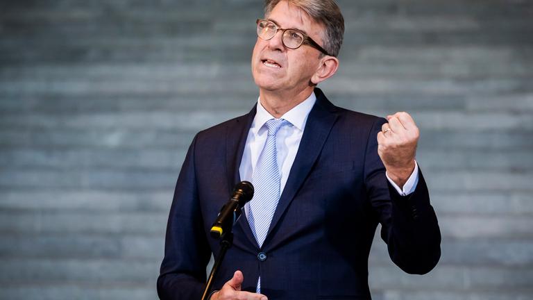 Mann steht am Mikrofon und ballt die Faust