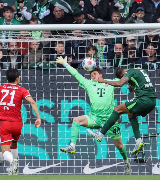Wolfsburgs Mittelfeldspieler Vinícius Souza köpft den Ball aufs Tor, doch Bayerns Torwart Jonas Urbig kann parieren
