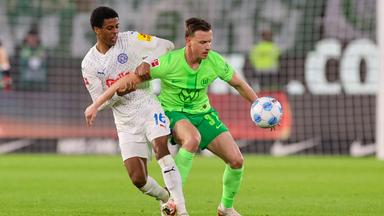 Andu Kelati von Holstein Kiel und Yannick Gerhardt vom VfL Wolfsburg kämpfen um den Ball