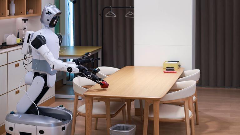 Ein Roboter ordnet während des „Household Scenario Event“ bei den 2. World Humanoid Robot Games am 18.08.2026 in Peking, China, Gegenstände auf einem Tisch an. 
