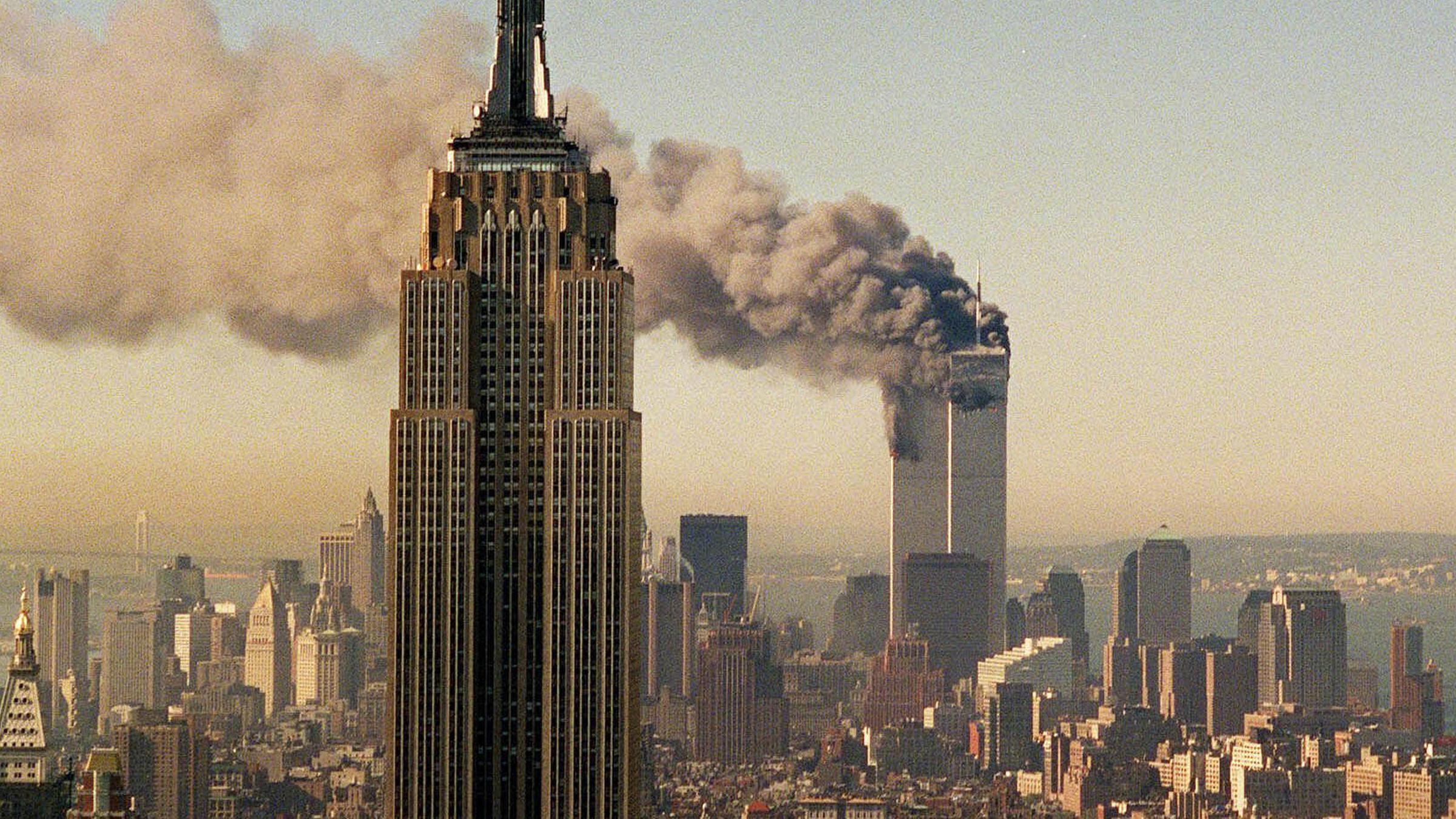 Archiv: Brennendes World Trade Center im Hintergrund des Empire State Buildings am 11.09.2001