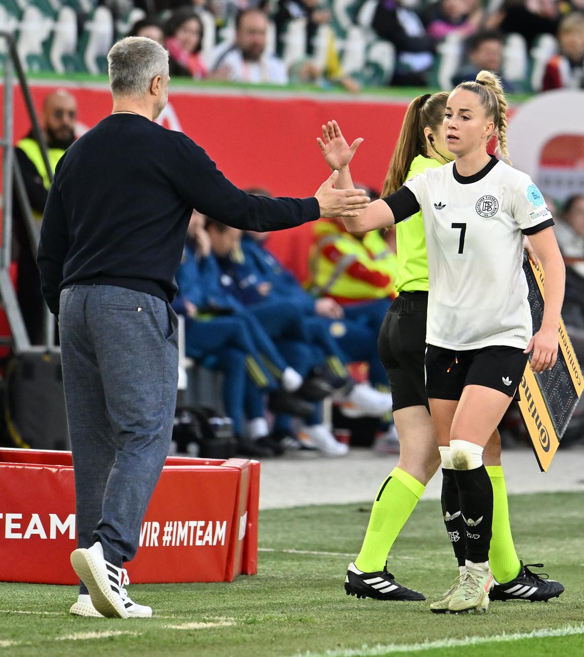 Giulia Gwinn klatscht bei ihrer Auswechselung mit Bundestrainer Christian Wück ab.