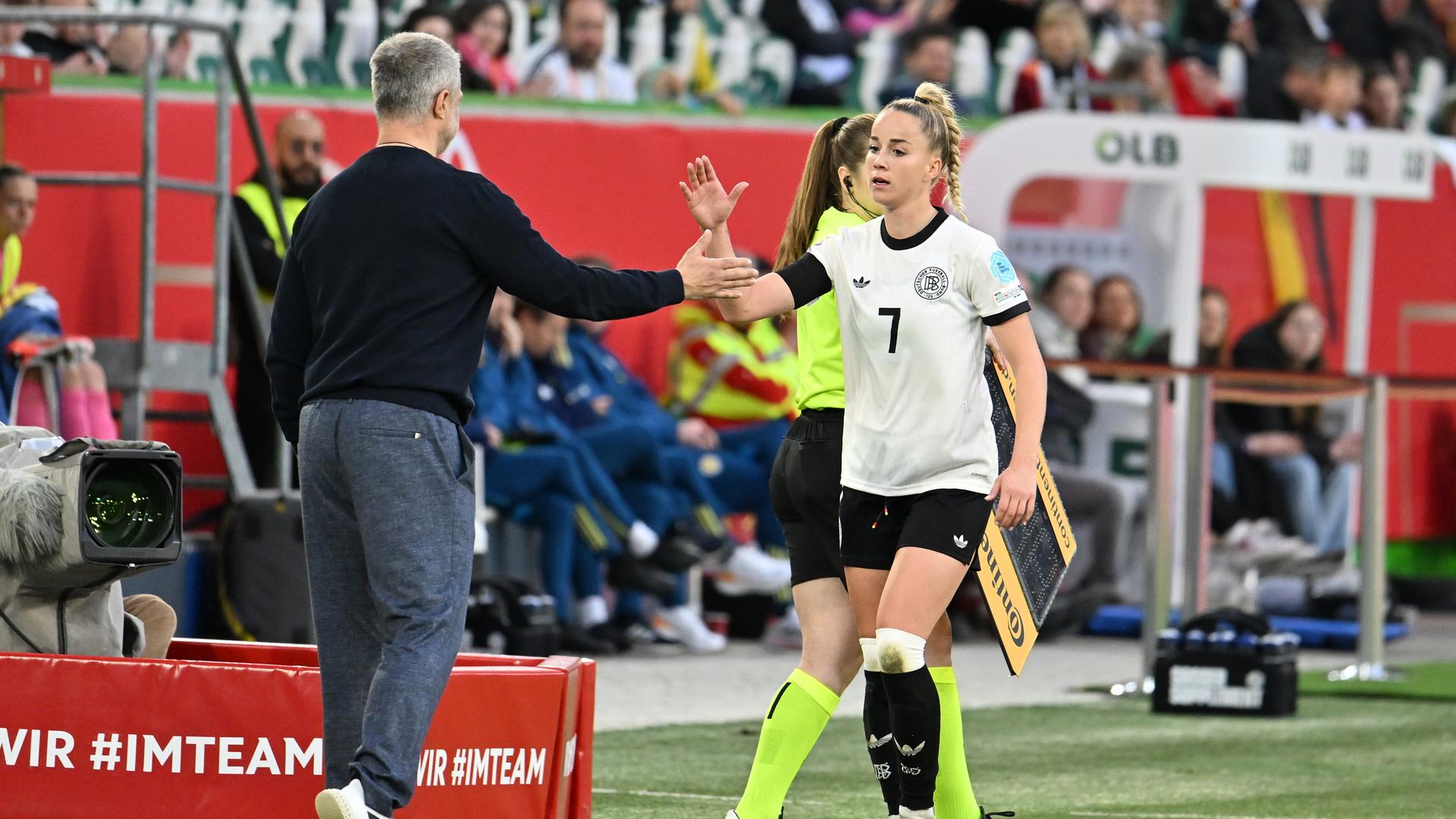 Giulia Gwinn klatscht bei ihrer Auswechselung mit Bundestrainer Christian Wück ab.
