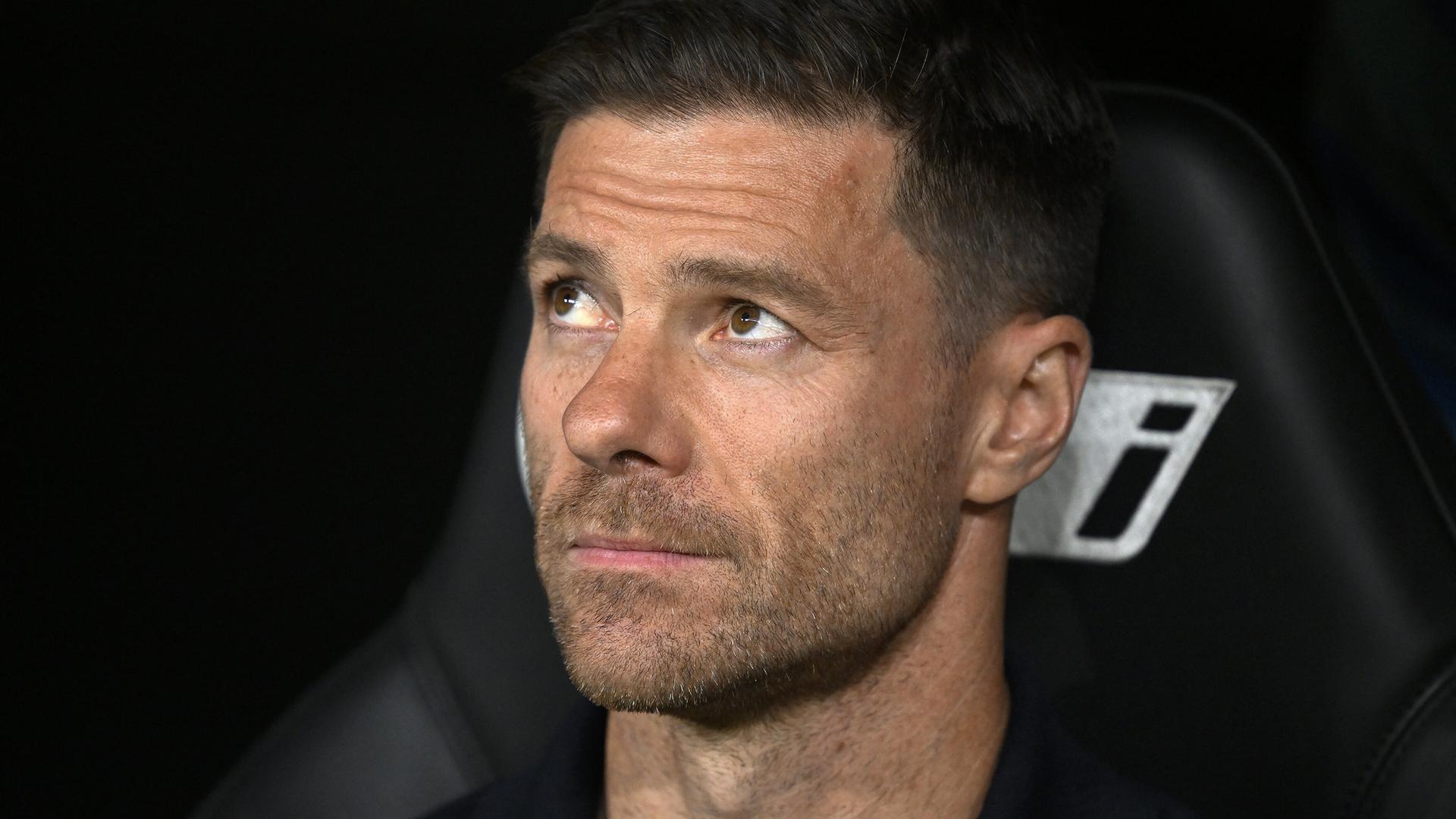 Xabi Alonso sitzt auf der Trainerbank und schaut nachdenklich nach oben