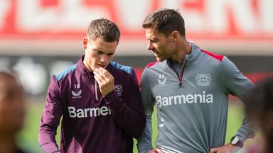 Xabi Alonso (r) unterhält sich beim Abschlusstraining mit Florian Wirtz.