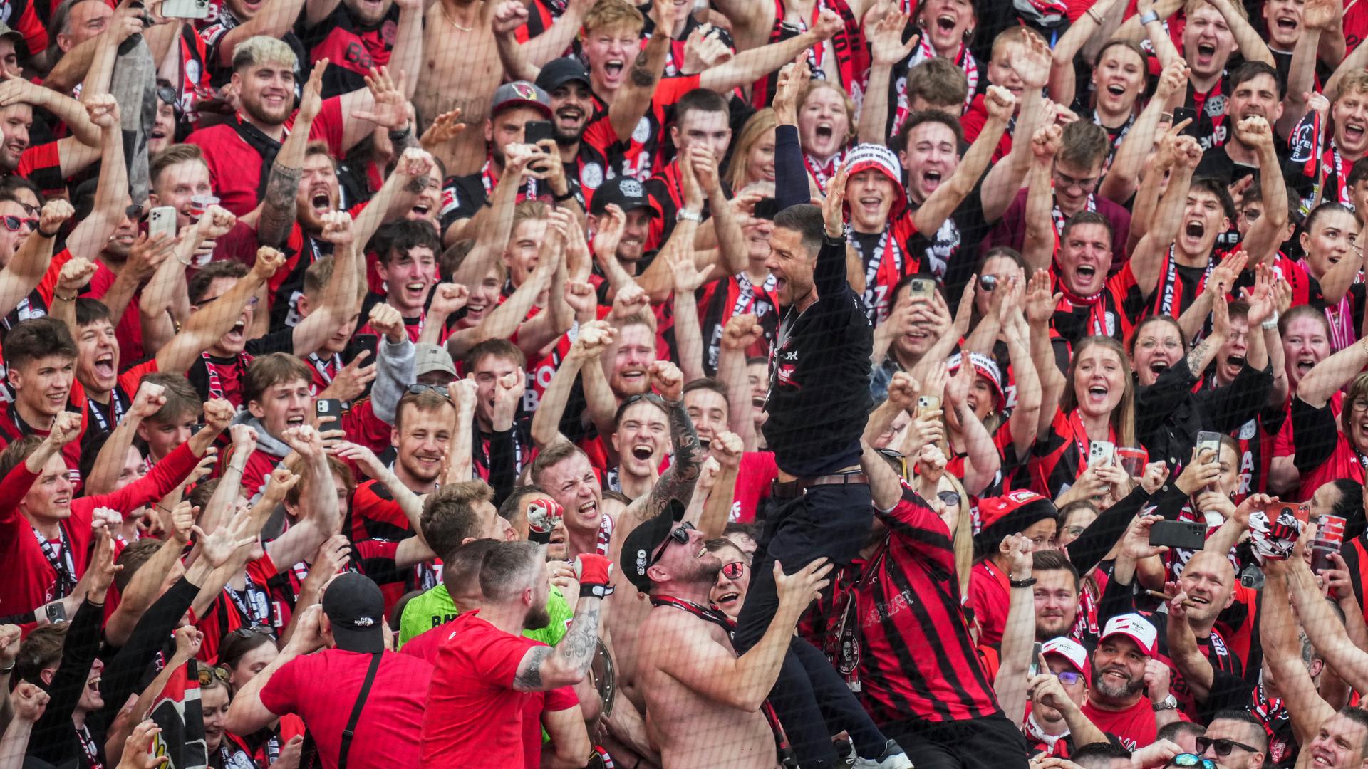 Leverkusens Trainer Xabi Alonso feiert mit Fans am 18.05.24.