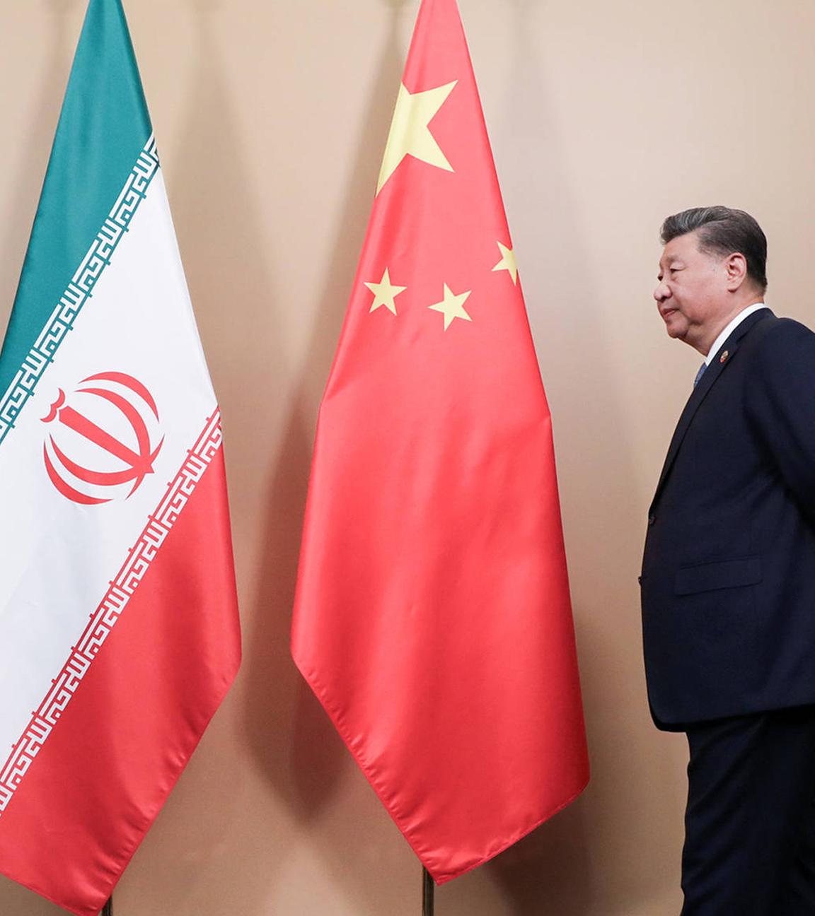 Xi Jinping Staatspräsident der Republik China steht neben Flaggen des Iran und der Volksrepublik China. (Archiv)