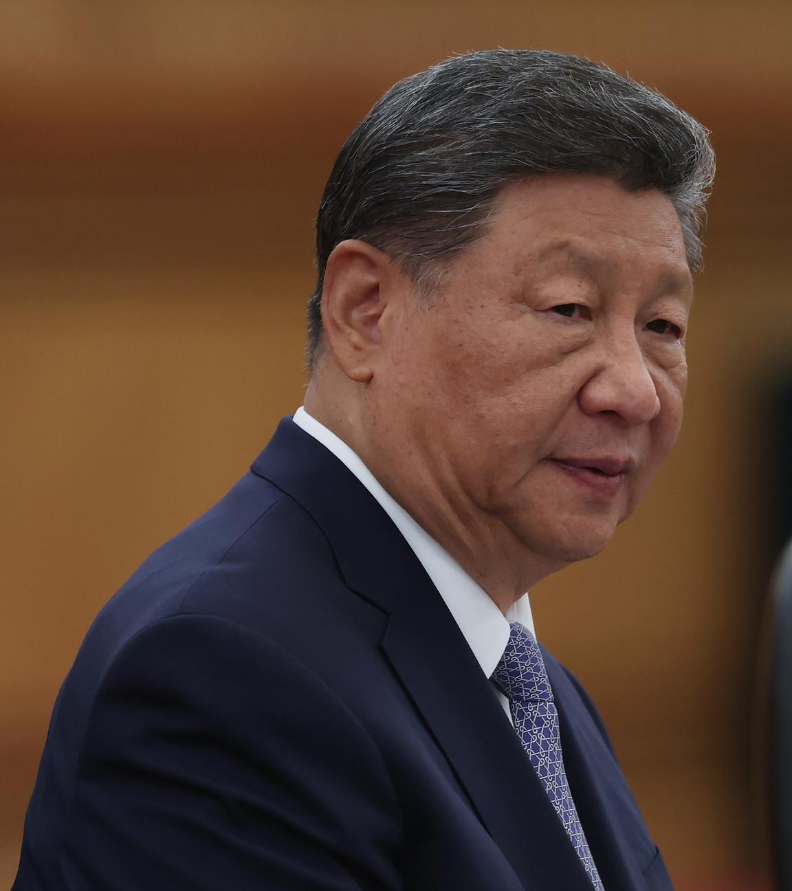Xi Jinping in einem Ledersessel mit ernstem Blick.