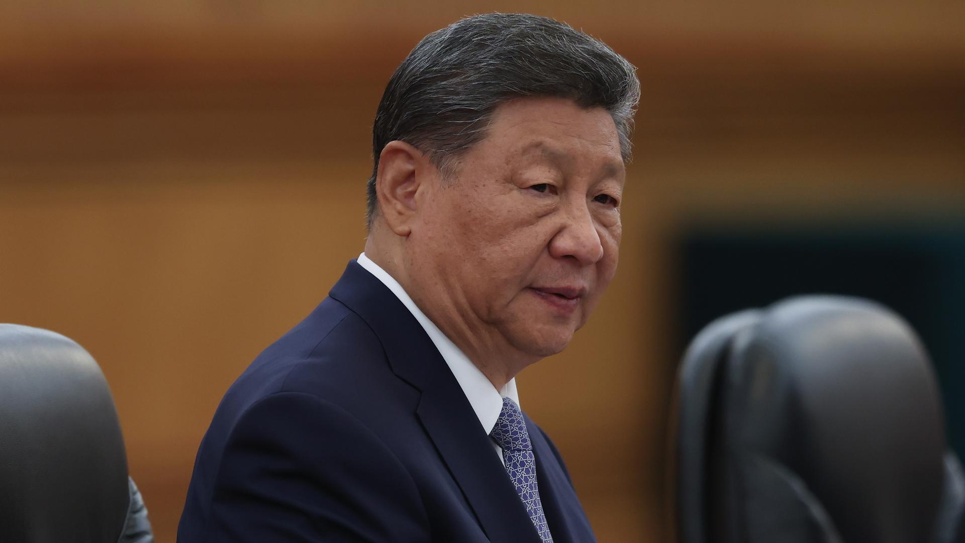 Xi Jinping in einem Ledersessel mit ernstem Blick.