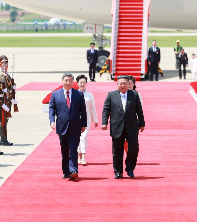Xi Jinping und seine Frau Peng Liyuan werden bei ihrer Ankunft auf dem Flughafen vor einem Flugzeug auf einem roten Teppich von Kim Jong Un und seiner Frau Ri Sol Ju zu einem zweitägigen Staatsbesuch begrüßt.