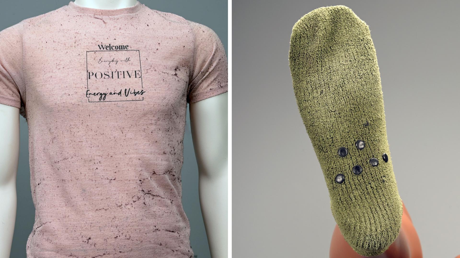 Die Kleidung der Toten: ein rosafarbenes, leicht transparentes T-Shirt mit dem Aufdruck "Welcome everyday with positive energy and vibe" (l.); grüne Socken mit rutschfesten Noppen (r.)