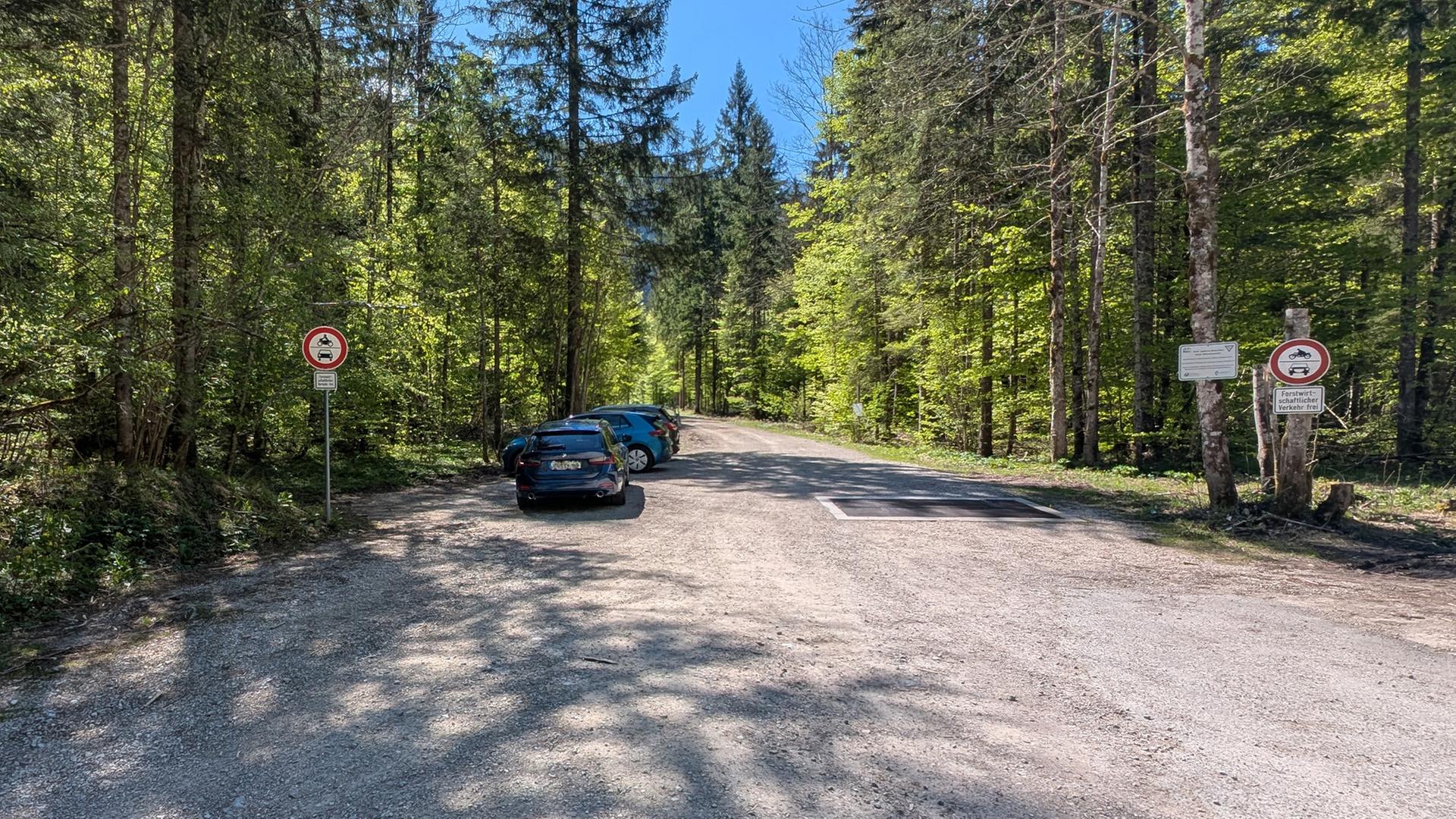 Ein Wanderparkplatz am Fuße eines bewaldeten Berges in Ruhpolding