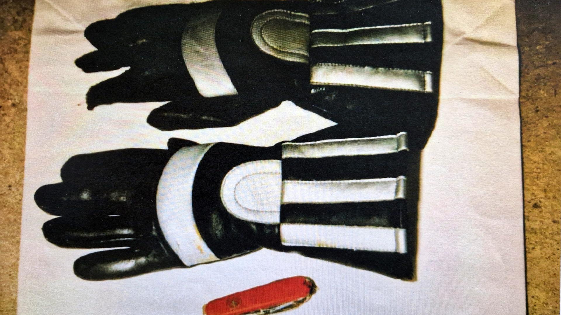 Schwarze Motorrad-Handschuhe mit silbernen Reflektoren und ein rotes Schweizer Taschenmesser