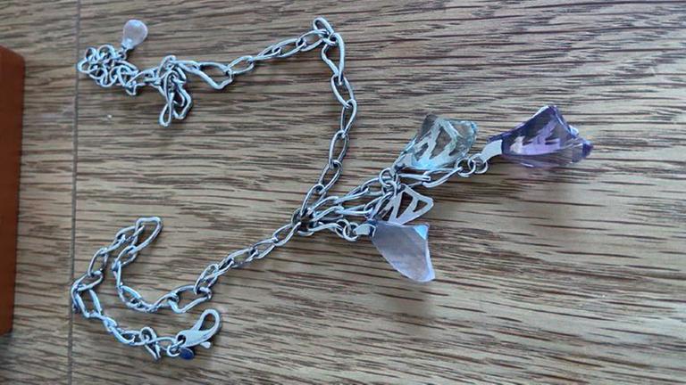 Erbeutete Weißgoldkette mit drei lilafarbenen Amethysten.