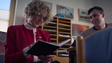 Nachgestellte Szene: Eine Frau schreibt in ein Notizbuch.