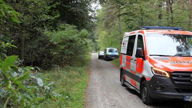 Einsatzkräfte auf dem Weg zum Tatort im Stadtwald in Lampertheim