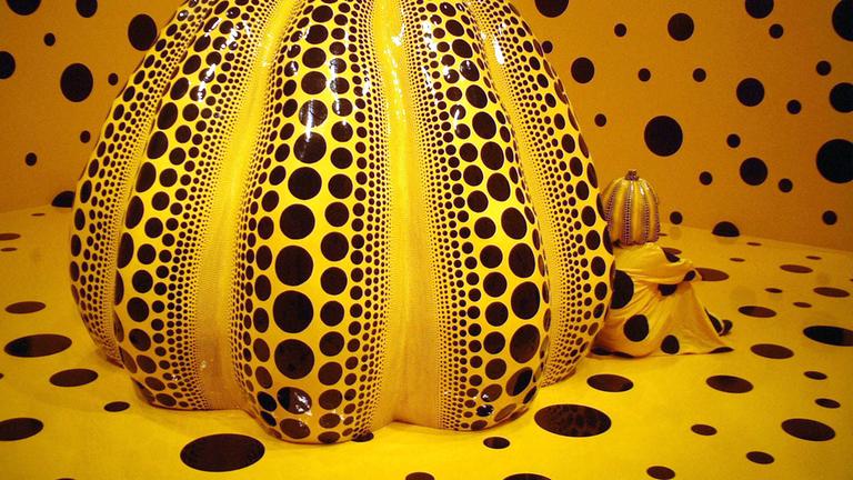 kusama, yayoi sitzt neben ihrem kunstwerk