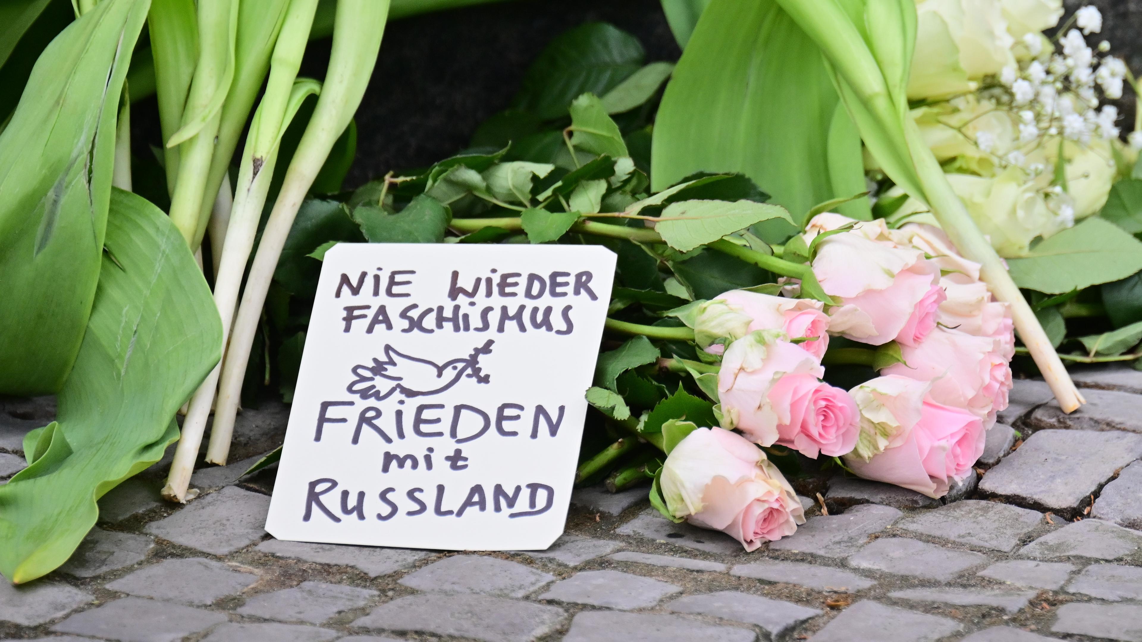 Ein Schild mit der Aufschrift Nie wieder Faschismus - Frieden mit Russland liegt vor einem Eingang zur russischen Botschaft.