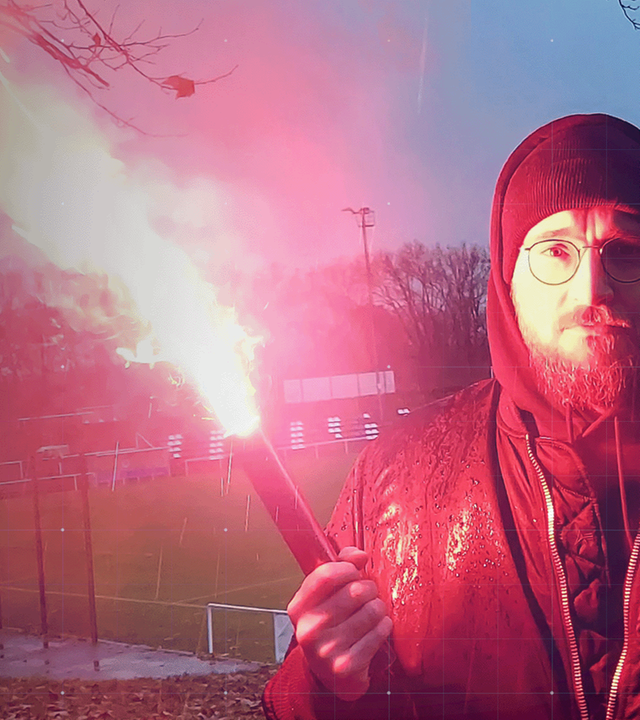 frontal-Host Nico Heimer mit Bengalfackel in leerem Fußballstadion