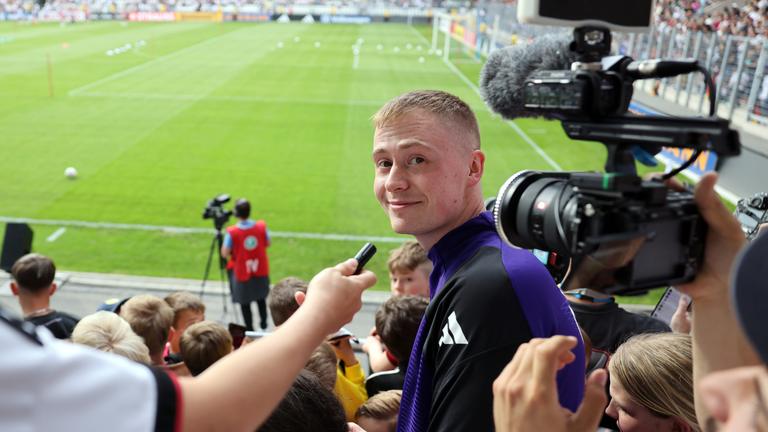 Youtuber Marvin Wildhage steht während des öffentlichen Trainings in Jena auf der Tribüne.