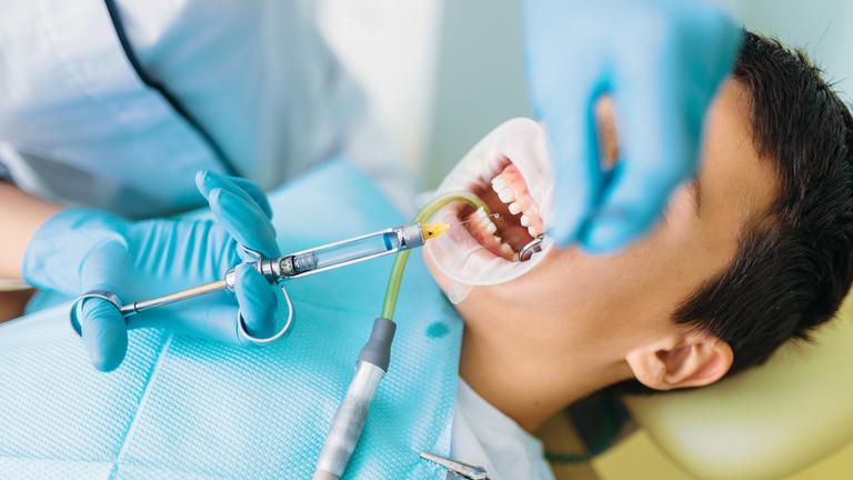 Archiv: Eine Zahnärztin begutachtet die Zähnen eines Jungen in einer Zahnklinik, aufgenommen am 01.06.2022