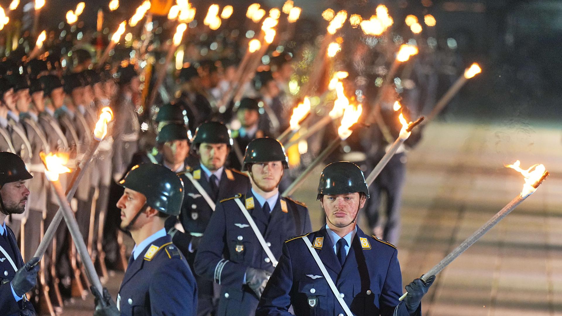 Soldatinnen und Soldaten des Wachbataillons kommen mit Fackeln zum großen Zapfenstreich der Bundeswehr anlässlich der Verabschiedung des geschäftsführenden Bundeskanzlers Olaf Scholz (SPD). 