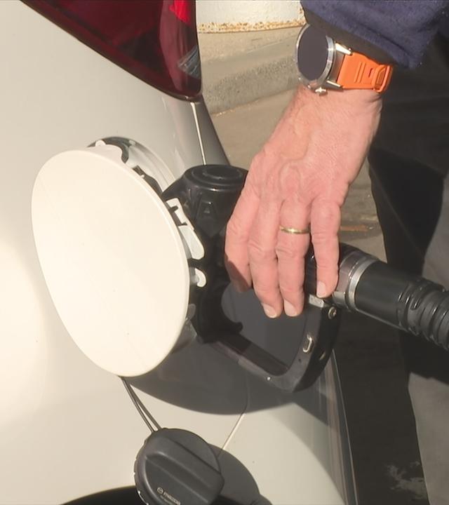 Person an der Zapfsäule