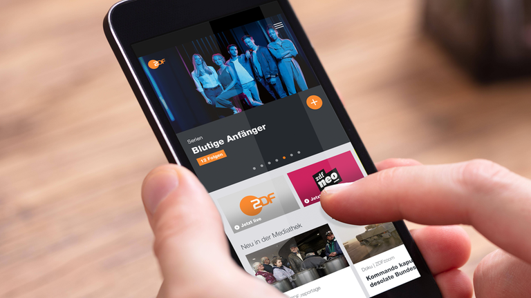 Ein Mann hat die ZDFmediathek PWA auf seinem Smartphone geöffnet