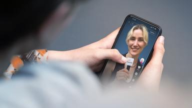 Eine Person hält ein Smartphone in der Hand, auf dem der TikTok-Kanal der ZDFheute zu sehen ist. 