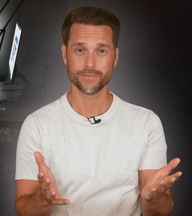Rechts im Bild zu sehen ist der Host Mirko Drotschmann. Links im Bild sitzt ein Mann am Schriebtisch und arbeitet.