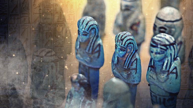 Blaue Tonfiguren voreiner Hieroglyphenwand mit Nebel- und Funkeneffekten.