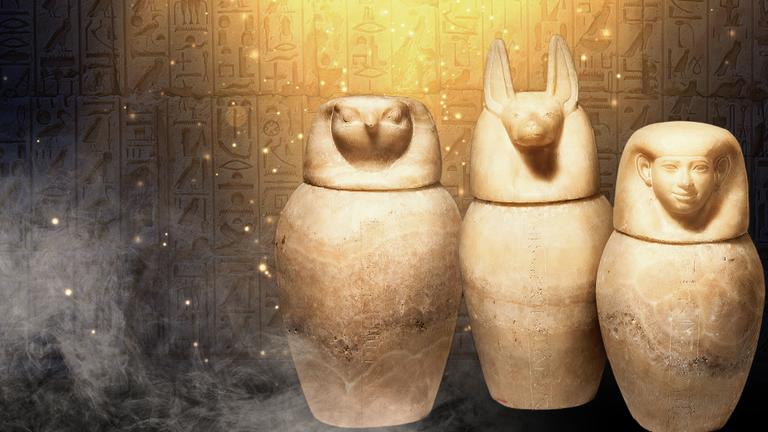 Drei Sarkophage vor einer Hieroglyphenwand mit Nebel und Funkeneffekten.