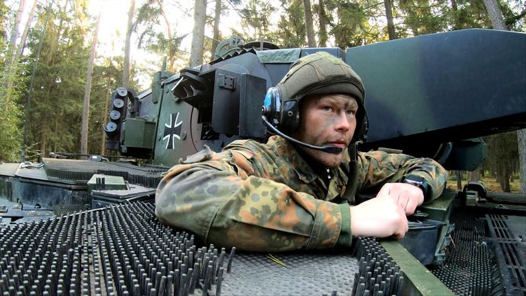 Bei einer Übung für Panzergrenadiere schaut ein Soldat aus einem Panzer heraus.