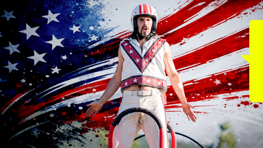 Ein Zirkusartist mit Helm und weißem Anzug posiert, im Hintergrund künstlerisch die amerikanische Flagge.